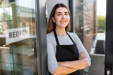 Image showing happy woman with reopen banner on door glass