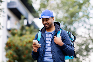 Image showing smiling indian delivery man with bag and phone