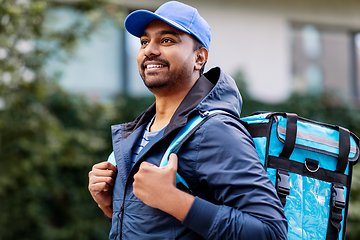 Image showing happy smiling indian delivery man with bag in city