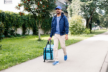 Image showing indian delivery man with bag walking in city