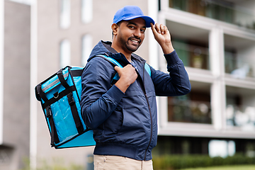 Image showing happy smiling indian delivery man with bag in city