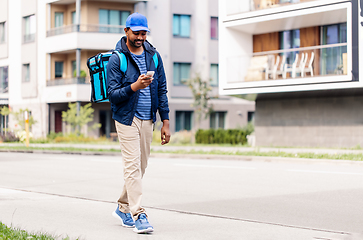 Image showing smiling indian delivery man with bag and phone