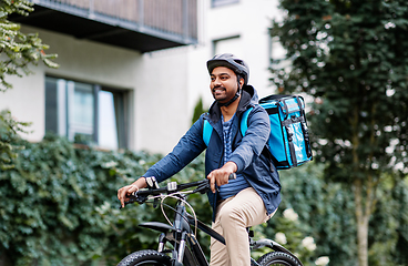 Image showing indian delivery man with bag riding bicycle