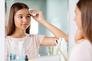 Image showing teenage girl cleaning face skin with cotton disc