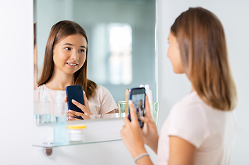 Image showing teenage girl looking in mirror and taking selfie