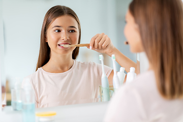 Image showing teenage girl with toothbrush brushing teeth