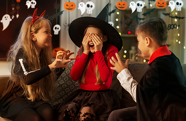 Image showing kids in halloween costumes playing at home