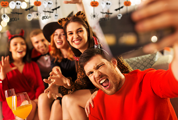 Image showing happy friends in halloween costumes taking selfie