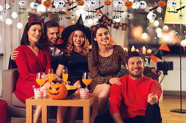 Image showing happy friends in halloween costumes taking selfie