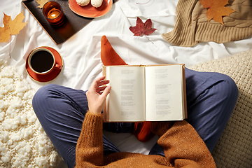 Image showing young woman reading book at home in autumn