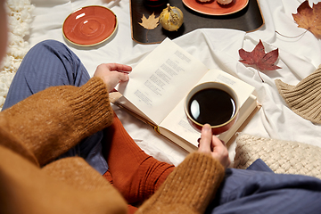 Image showing woman drinking coffee and reading book in autumn