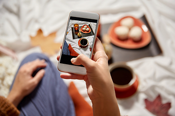 Image showing woman with smartphone taking picture of autumn set