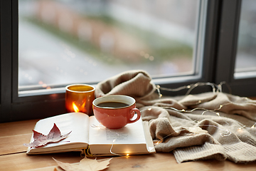 Image showing cup of coffee, book on window sill in autumn