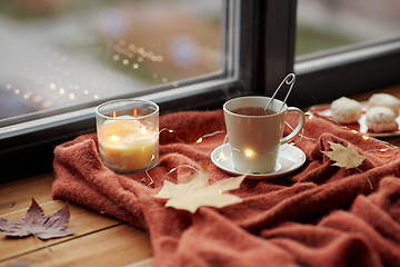 Image showing cup of tea and candle on window sill in autumn