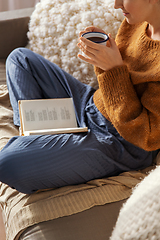 Image showing woman drinking coffee and reading book at home