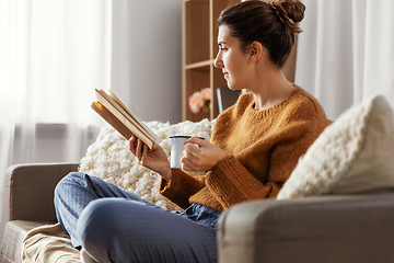 Image showing woman drinking coffee and reading book at home