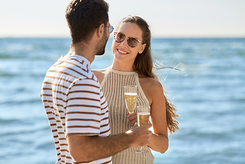 Image showing happy couple drinking champagne on summer beach