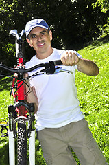 Image showing Man carrying a bicycle