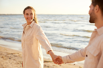 Image showing happy couple holding hands on summer beach