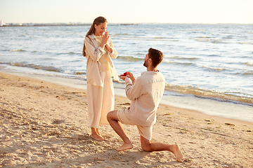 Image showing man with ring making proposal to woman on beach