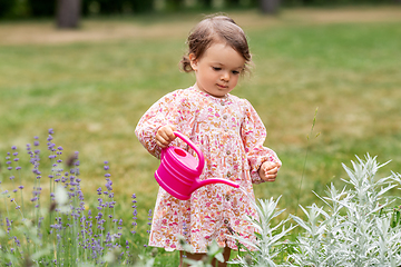 Image showing happy baby girl with watering can in summer garden