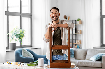 Image showing happy man renovating old wooden table at home