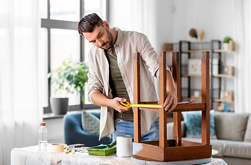 Image showing man with ruler measuring table for renovation