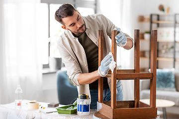 Image showing man cleaning old table surface with tissue