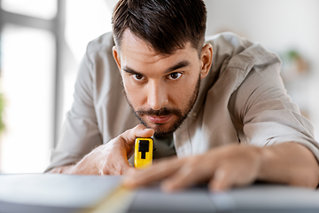 Image showing man with ruler measuring table for renovation