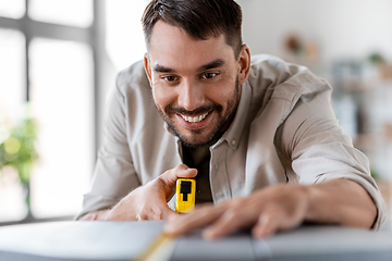 Image showing man with ruler measuring table for renovation