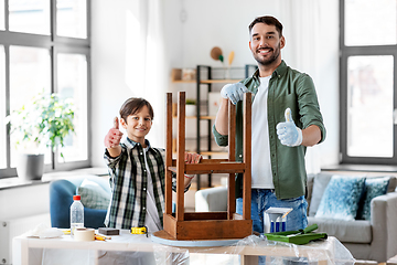 Image showing father and son sanding old table with sponge