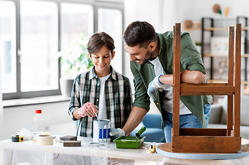 Image showing father and son stirring grey color paint at home