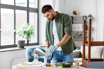 Image showing man opening can with grey color at home