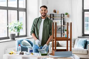 Image showing man painting old table in grey color at home