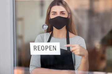 Image showing woman in mask with reopen banner on door glass