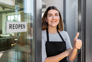 Image showing woman with reopen banner on door showing thumbs up