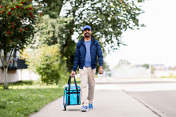 Image showing indian delivery man with bag walking in city