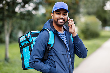 Image showing indian delivery man with bag calling on smartphone