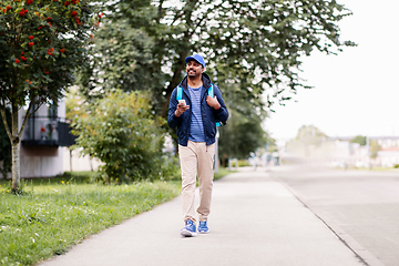 Image showing smiling indian delivery man with bag and phone