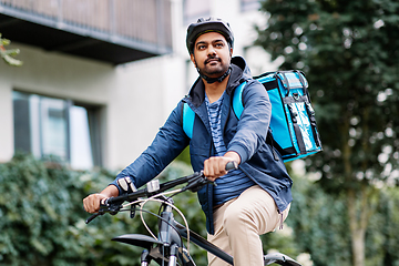 Image showing indian delivery man with bag riding bicycle