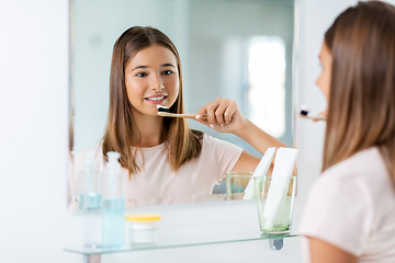 Image showing teenage girl with toothbrush brushing teeth