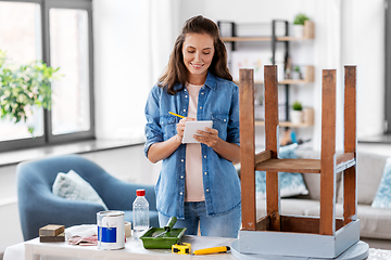 Image showing woman with old table writing to notebook at home