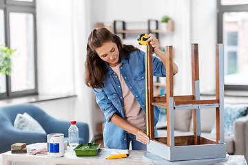 Image showing woman with ruler measuring table for renovation