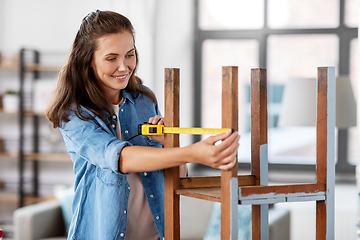 Image showing woman with ruler measuring table for renovation