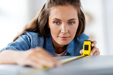 Image showing woman with ruler measuring table for renovation