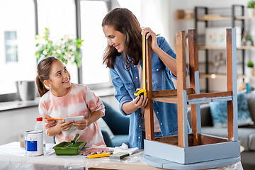 Image showing mother and daughter with ruler measuring old table