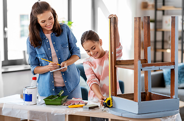 Image showing mother and daughter with ruler measuring old table