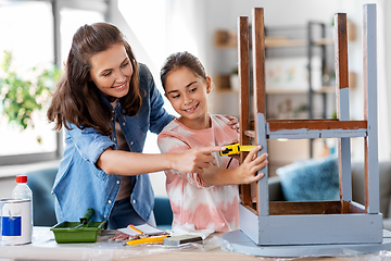 Image showing mother and daughter with ruler measuring old table