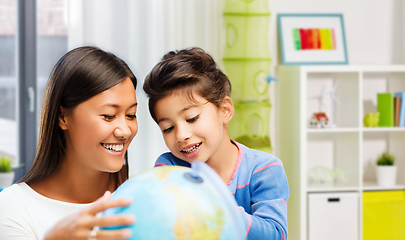 Image showing mother and daughter with globe at home