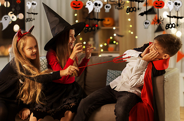 Image showing kids in halloween costumes playing at home